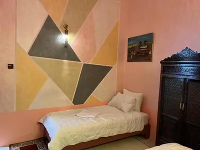 a bedroom with a bed and a geometric wall at Riad Dar Oum Albanin in Fès