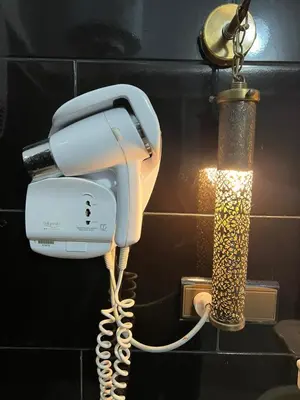 a white phone hanging on a wall next to a lamp at Riad Dar Oum Albanin in Fès