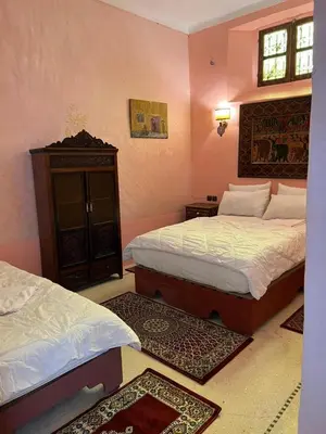 a bedroom with two beds and two rugs at Riad Dar Oum Albanin in Fès