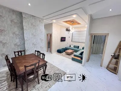a living room with a table and a couch at White Cactus in Meknès