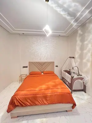 a bedroom with a bed with an orange blanket at White Cactus in Meknès