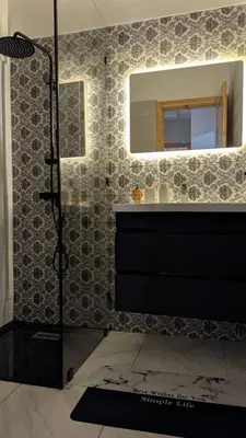 a bathroom with a shower and a sink and a mirror at NAYA apartment in Fès