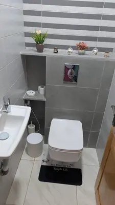 a bathroom with a white toilet and a sink at NAYA apartment in Fès