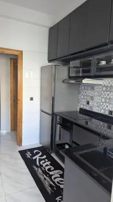 a kitchen with a stainless steel refrigerator and a kitchen rug at NAYA apartment in Fès