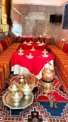 a room with two tables with plates and bowls on it at Kasbat Taslit in Ouarzazate
