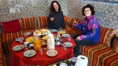 a man and woman sitting at a table with food at Kasbat Taslit in Ouarzazate