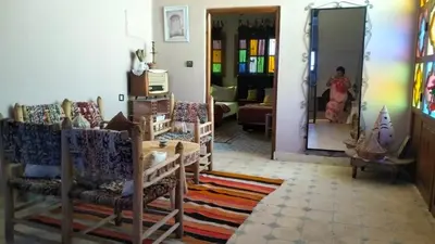 a living room with a woman looking in a mirror at Kasbat Taslit in Ouarzazate