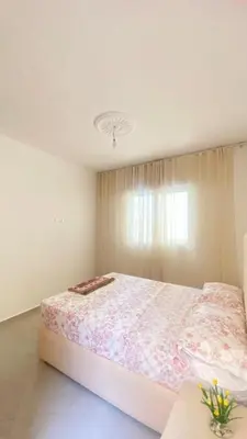 a bedroom with a large bed with a floral bedspread at manar immobilier Appart Msnana Golf in Oulad Akkou