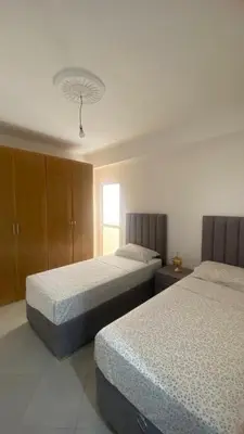 a bedroom with two beds and a window at manar immobilier Appart Msnana Golf in Oulad Akkou
