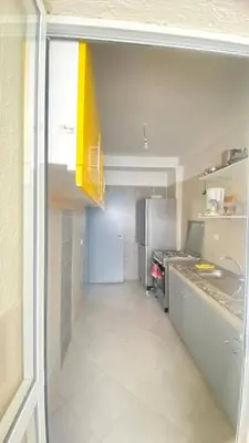 a small kitchen with a refrigerator and a sink at manar immobilier Appart Msnana Golf in Oulad Akkou