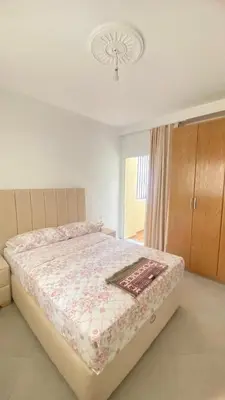 a bedroom with a large bed with a floral bedspread at manar immobilier Appart Msnana Golf in Oulad Akkou