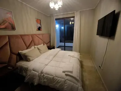 a bedroom with a large white bed with a headboard at villa Les Jardins D'atlas in Oulad Akkou