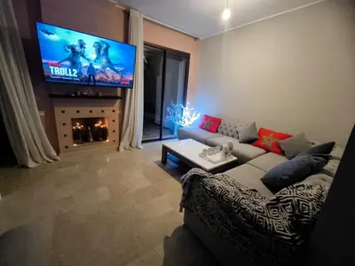 a living room with a couch and a flat screen tv at villa Les Jardins D'atlas in Oulad Akkou