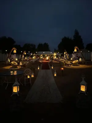 a courtyard with candles and chairs at night at Dunes Luxury Lodge in Merzouga