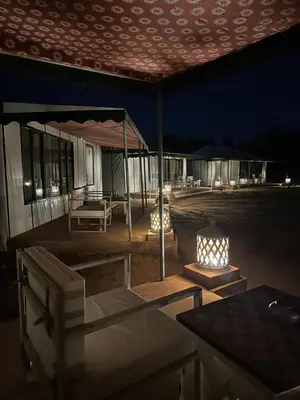 a patio with a table and chairs under a tent at Dunes Luxury Lodge in Merzouga