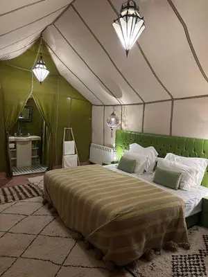 a bedroom with a large bed in a tent at Dunes Luxury Lodge in Merzouga