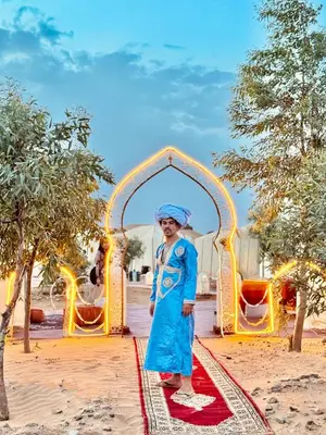 a man standing in front of an arch at Merzouga Luxury Camp in Merzouga