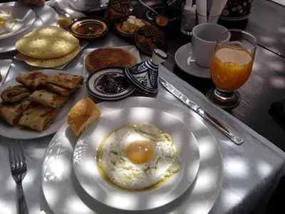 a table with a plate of eggs and bread at Kasbah Tissint in Tissint