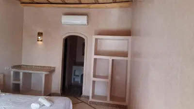 a bedroom with a bed and a room with a window at Kasbah Tissint in Tissint