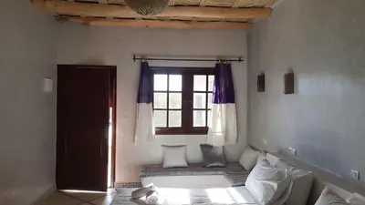 a bedroom with a window and a bed with pillows at Kasbah Tissint in Tissint