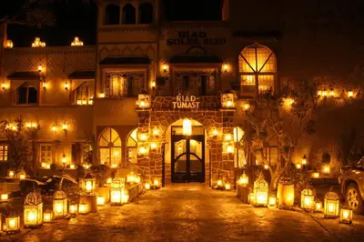a building with lights in front of it at night at Hotel Soleil Blue in Boumalne