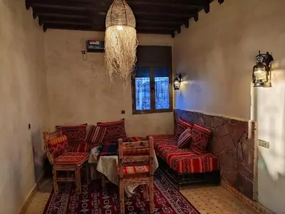 a living room with a couch and a table and chairs at Camels house apartment in Hassilabied