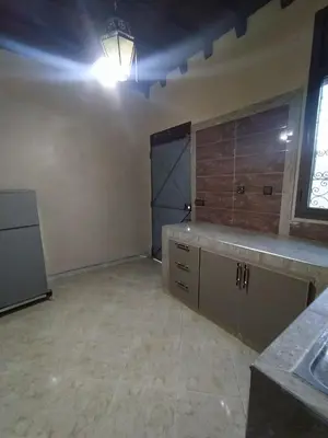 an empty room with a kitchen with a large door at Camels house apartment in Hassilabied