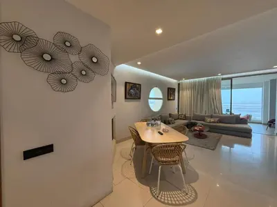 a living room with a table and a couch at Very nice apartment with sea and pool views in Oulad Akkou