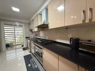 a kitchen with a black counter top and a stove at Very nice apartment with sea and pool views in Oulad Akkou