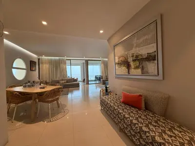 a living room with a couch and a table and a dining room at Very nice apartment with sea and pool views in Oulad Akkou