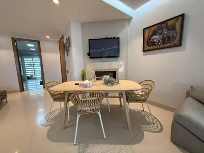 a living room with a table and a fireplace at Very nice apartment with sea and pool views in Oulad Akkou