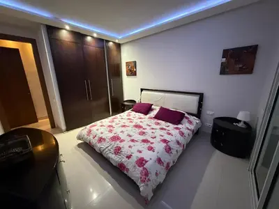a bedroom with a bed with purple pillows at Very nice apartment with sea and pool views in Oulad Akkou