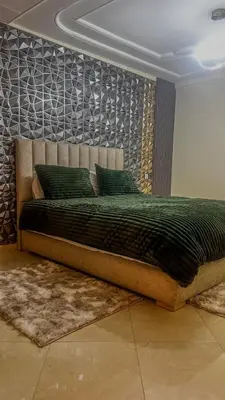 a bedroom with a large bed with green pillows at My Amir in Fès