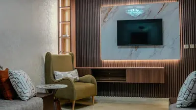 a living room with a tv and a couch and a chair at My Amir in Fès