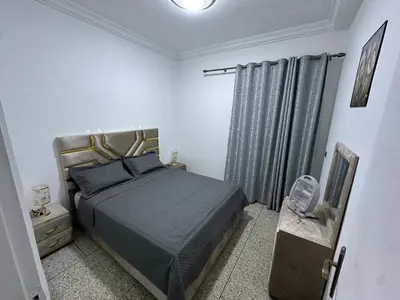 a bedroom with a bed in a white room at Apartment 5 mins from downtown in Fès