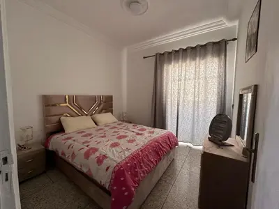 a bedroom with a large bed and a window at Apartment 5 mins from downtown in Fès