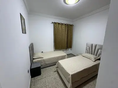 a bedroom with two beds and a window in it at Apartment 5 mins from downtown in Fès