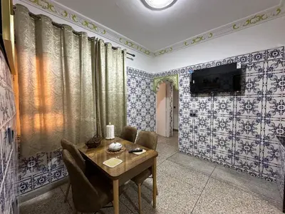 a living room with blue and white tiled walls at Apartment 5 mins from downtown in Fès