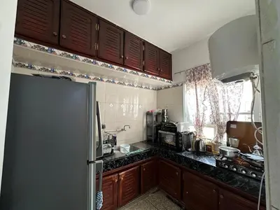 a kitchen with wooden cabinets and a refrigerator at Apartment 5 mins from downtown in Fès