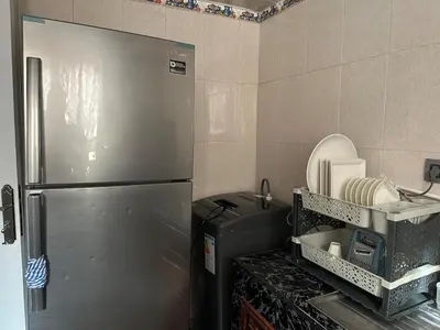 a kitchen with a stainless steel refrigerator and a sink at Apartment 5 mins from downtown in Fès
