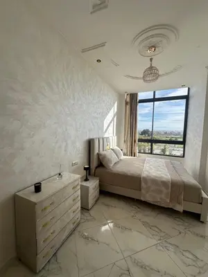 a bedroom with a large bed and a large window at Appartement de standing supérieur à Fès en Route de Meknès in Douar Trhaïtia