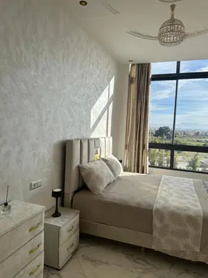 a bedroom with a bed and a large window at Appartement de standing supérieur à Fès en Route de Meknès in Douar Trhaïtia