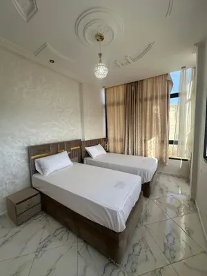 two beds in a room with marble floors at Appartement de standing supérieur à Fès en Route de Meknès in Douar Trhaïtia
