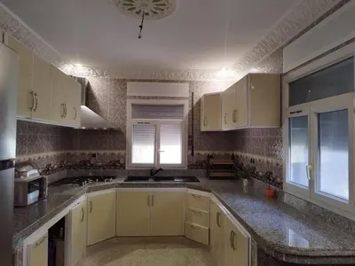 a kitchen with white cabinets and granite counter tops at Luxurious mountain villa in El Ksiba