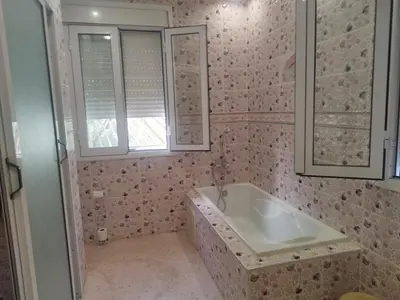 a bathroom with a tub and a sink and a window at Luxurious mountain villa in El Ksiba