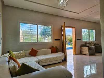 a living room with a white couch and windows at Villa rue imouzzer in Fès