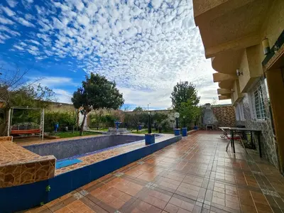 a building with a swimming pool with a cloudy sky at Villa rue imouzzer in Fès