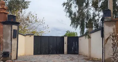 a black gate in front of a house at Les Domes de l Ourika in Sidi Bouzguia