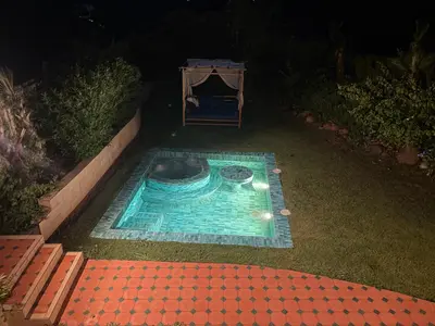 a small swimming pool in a yard at night at Les Domes de l Ourika in Sidi Bouzguia