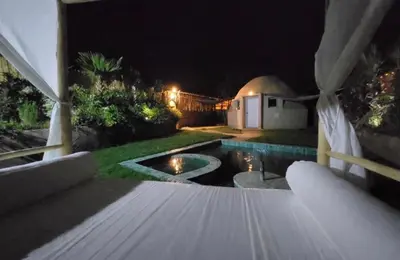 a backyard at night with a swimming pool at Les Domes de l Ourika in Sidi Bouzguia